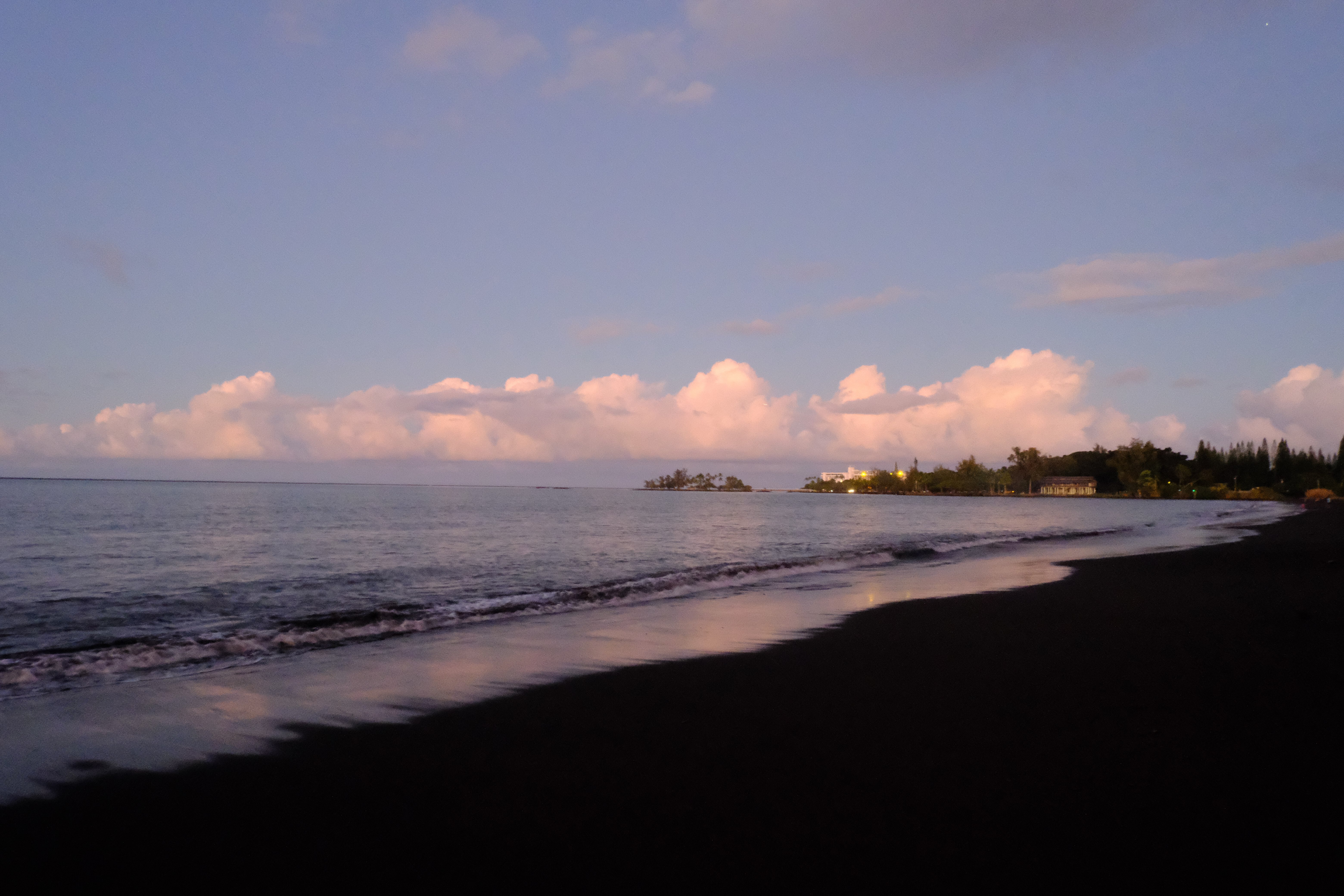 pink sunset photo taken on a black sand beach of the ocean